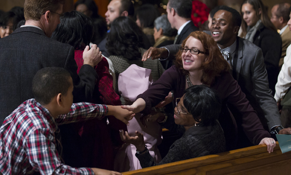 PEOPLE EXCHANGE SIGN OF PEACE DURING CHRISTMAS EVE MASS AT NATIONAL SHRINE IN WASHINGTON