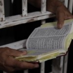 Inmate Prisoner Reading Holy Bible in Jail Prison Penitentiary Wide Pic