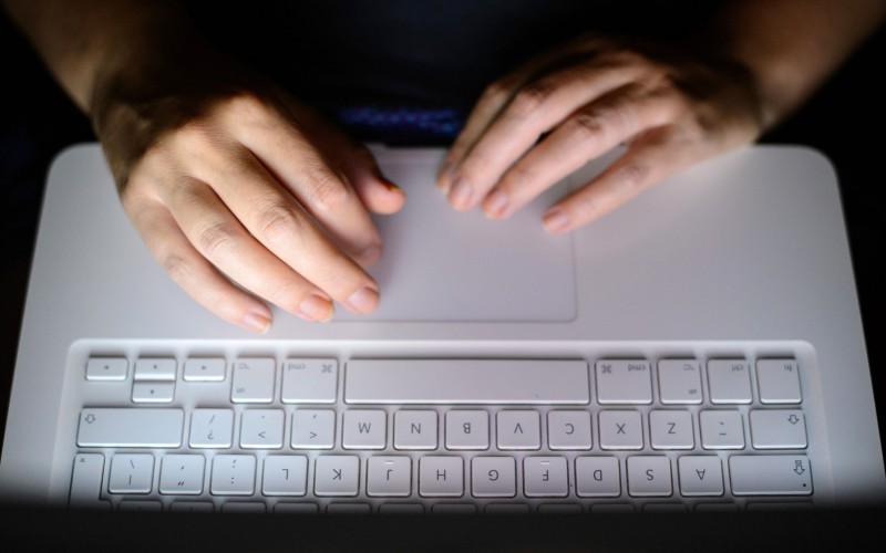 Computer Keyboard with Hands dark room light from screen