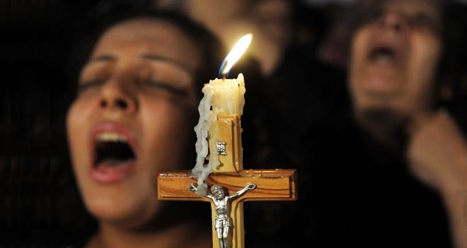 Coptic Christians carry a crucifix and chant prayers during a candlelight protest at Abassaiya Orthodox Cathedral in Cairo Oct. 16, one week after people were killed during clashes with soldiers and riot police. At least 26 people, mostly Christians, were killed Oct. 9 when troops broke up a peaceful protest against an earlier attack on a church in southern Egypt. (CNS photo/stringer via Reuters) (Oct. 18, 2011) See EGYPT-CHRISTIANS Oct. 10, 2011.