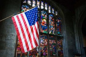 u-s-flag-and-stained-glass-window-inside-catholic-church