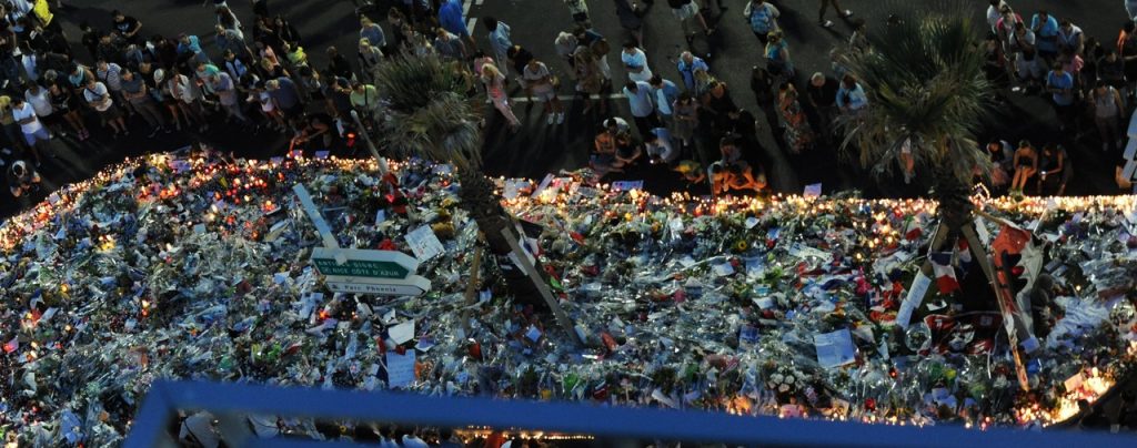 epa05429785 People gather at a makeshift memorial of flowers and candles on the 'Promenade des Anglais' where the truck crashed into the crowd during the Bastille Day celebrations, in Nice, France, 17 July 2016. According to reports, at least 84 people died and many were wounded after a truck drove into the crowd on the famous Promenade des Anglais during celebrations of Bastille Day in Nice, late 14 July. EPA/OLIVIER ANRIGO