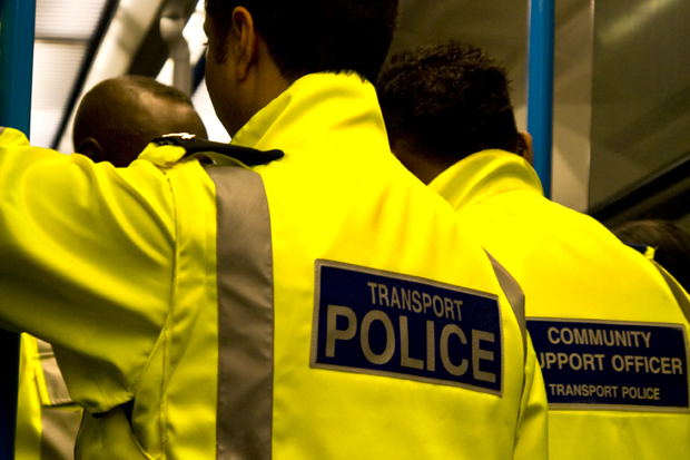 Transport police and community support officers travelling between stops on a dark South London train.